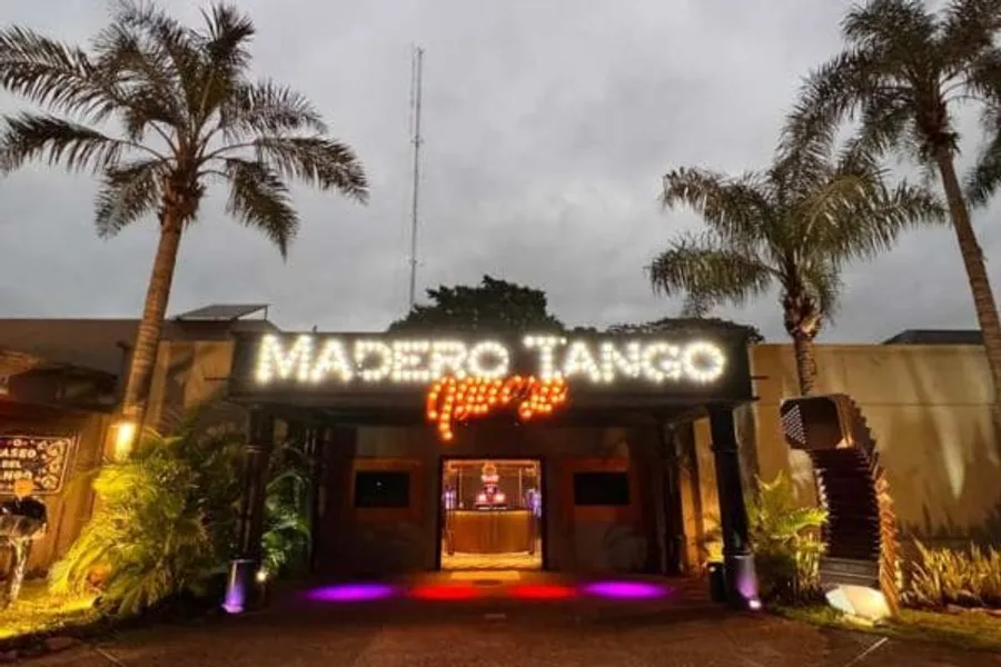 Entrada iluminada de una casa de tango en Puerto Iguazú de noche