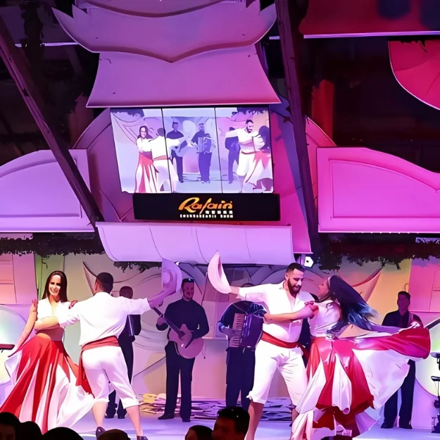 Palco do Rafain Churrascaria Show iluminado durante a apresentação, visto do meio do salão